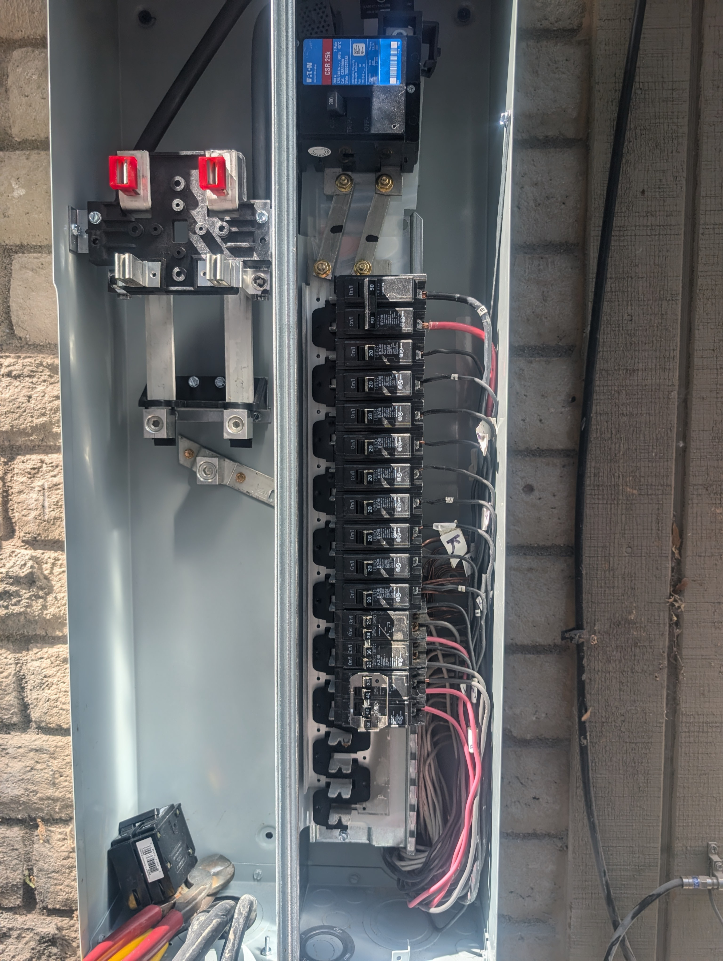 Open 200-amp Eaton service panel mid-installation with neatly landed branch circuit breakers